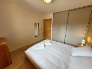 莱热Appartement Les Gets, 2 pièces, 4 personnes - FR-1-598-143的卧室配有一张白色大床和两条毛巾