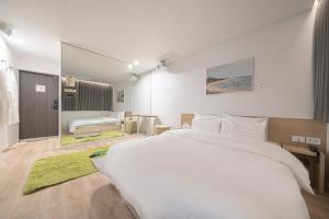 大田Aank Hotel Daejeon Yuseongonsen 2nd的一间带白色大床的卧室和一间客厅