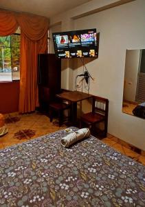 廷戈玛丽亚HOSPEDAJE EL CANTARO的卧室配有一张床,墙上配有电视。