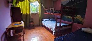 廷戈玛丽亚HOSPEDAJE EL CANTARO的小房间设有两张双层床和一张桌子