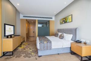 成都成都英联金盛国际酒店的一间卧室配有一张床和一台平面电视