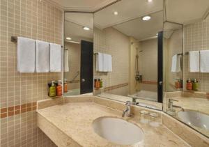 新加坡Holiday Inn Singapore Atrium, an IHG Hotel的一间带两个盥洗盆和大镜子的浴室