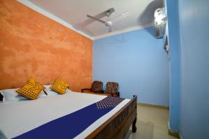 德奥加尔SPOT ON Shashi Prabha Palace的一间卧室设有一张黄色和蓝色墙壁的床