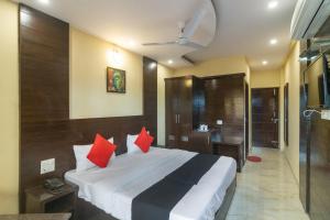 MājraCapital O Hotel Rudraksh的一间卧室配有一张带红色枕头的大床