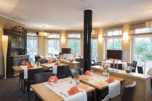 Kirchhatten迈纳斯酒店的餐厅设有木桌、椅子和窗户。