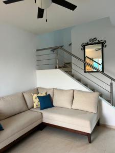 梅里达Casa Flor de Mayo, fresca, climas, en privada的客厅设有一张沙发,设有楼梯