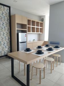 怡保八角形怡保公寓的厨房配有桌子、椅子和冰箱。