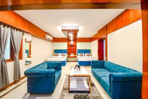 布巴内什瓦尔FabHotel Greenland Grand的客厅配有蓝色的沙发和桌子