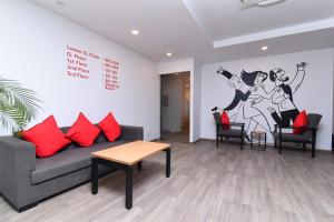 新德里Townhouse Rudra Inn Near Chhatarpur Metro Station的带沙发和红色枕头的客厅