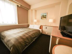 福山福山温泉格兰蒂亚路线度假酒店的配有一张床和一台平面电视的酒店客房