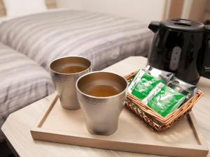 福山福山温泉格兰蒂亚路线度假酒店的桌上托盘上放两杯咖啡