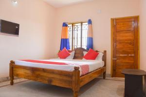 BārangFlagship Caroline Homestay的一间卧室配有一张带红色和蓝色枕头的木床。