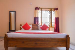 BārangFlagship Caroline Homestay的一间卧室配有一张带红色枕头的床和一扇窗户