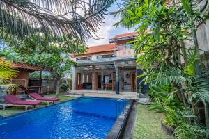 努沙杜瓦Villa Padma by Best Deals Asia Hospitality的一座树木繁茂的房屋前的游泳池