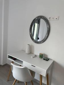 雅典Tiffany's apartments -2' walk from Metro的一张带椅子和镜子的白色书桌
