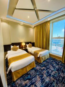 哈伊勒راحة للأجنحة الفندقية Comfort hotel suites的酒店客房设有两张床和窗户。
