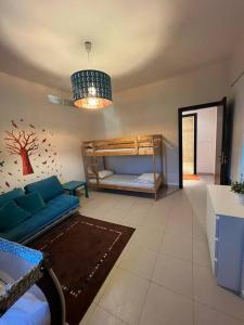 索瓦马Apartment at Samarah Dead Sea Resort的客厅配有蓝色的沙发和双层床。