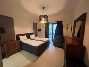 索瓦马Apartment at Samarah Dead Sea Resort的一间卧室配有一张床、梳妆台和镜子