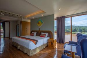 Naung BuaNakaburi Sanctuary Resort&Spa的一间卧室设有一张床和一个大窗户