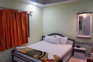 迪卡Goroomgo Muskan Guest House Digha的一间小卧室,配有一张床和镜子