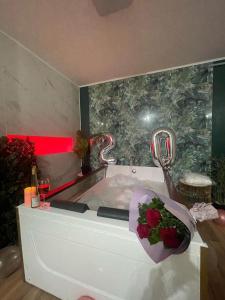 巴亚马雷Jacuzzi Apartment的浴室设有花束玫瑰花的浴缸