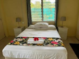 南迪Libby's Vacation Rental 2 Bed Home 1-4 Guests的一间卧室配有一张带花毯的大床