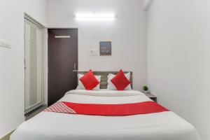 兰奇The Radium Inn的卧室配有带红色枕头的大型白色床