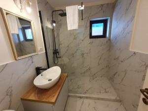 阿尔巴尤利亚Bloom Apartament的白色的浴室设有水槽和镜子