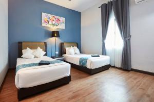 关丹D' Qamar Guesthouse的配有蓝色墙壁和木地板的客房中的两张床