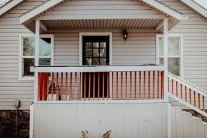 克拉马斯福尔斯The Shasta Cottage的白色的房子,带橙色栏杆的门廊
