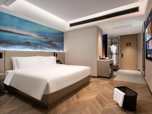 广州宜尚PLUS酒店- 广州珠江新城五羊邨地铁站店的卧室配有一张白色大床和一幅画