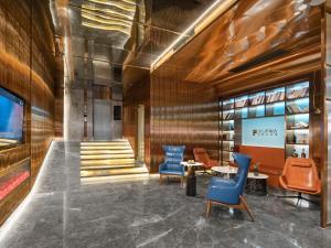 广州宜尚PLUS酒店- 广州珠江新城五羊邨地铁站店的大堂设有蓝色椅子、桌子和楼梯