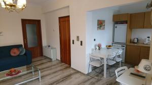 干尼亚Sunny family apartment in Chania close to the sea的一间带桌子的客厅和一间厨房