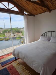 兰格班Aintree Lodge - Yoga Den的一间卧室设有一张床和一个大窗户