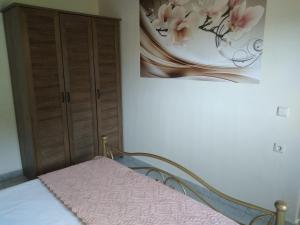 沃丽曼村Nature Villa的卧室配有一张床,墙上挂有绘画作品
