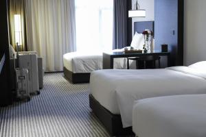 西安西安東舍酒店的酒店客房设有两张床和一张桌子。