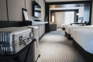 西安西安東舍酒店的酒店客房带两张床和行李箱