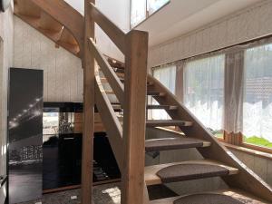 BlatnicaPenzión Encián的带壁炉的客房里设有木制螺旋楼梯