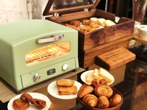 京都京都蒙特利酒店的坐在桌子上的绿色烤面包机,上面放有面包盘