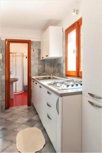 马里纳迪马萨WELLNESS VERSILIA -SAUNA & JACUZZI- Free Parking-的白色的厨房设有水槽和炉灶。