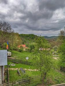 Proviţa de SusCabana „Stâna din Deal”的享有农场、围栏和田野的景色