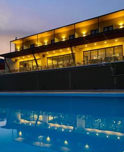 特里波利斯AKROTHEA suites & lounge的一座晚上设有游泳池的建筑