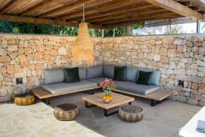 Sant RafaelVilla Romero Renovated的一个带沙发和桌子的庭院和石墙