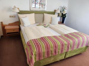 泰根塞法克勒公寓的一间卧室配有一张带条纹毯子的大床