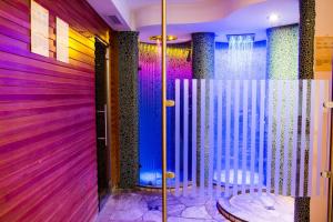 塞尔瓦迪加尔代纳山谷Apartments Aghel ***S的客房拥有紫色的墙壁和带椅子的淋浴。
