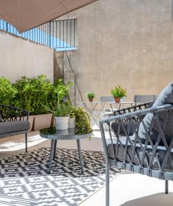 锡拉库扎Ortigia's gate的庭院配有桌椅和盆栽植物