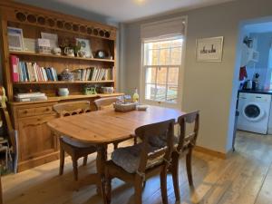 锡廷伯恩Green Cottages的一间带木桌和椅子的用餐室