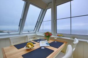 万根沃格Villa Marina - Gigantischer Meerblick的一间带桌子和一些窗户的用餐室