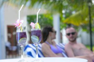 尼拉瓦利NN Beach Resort & SPA的两杯,桌上有两杯饮料