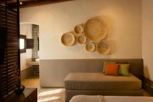 恩佩多克莱港Borgo delle Pietre的一间卧室配有一张床,墙上还装了一些篮子